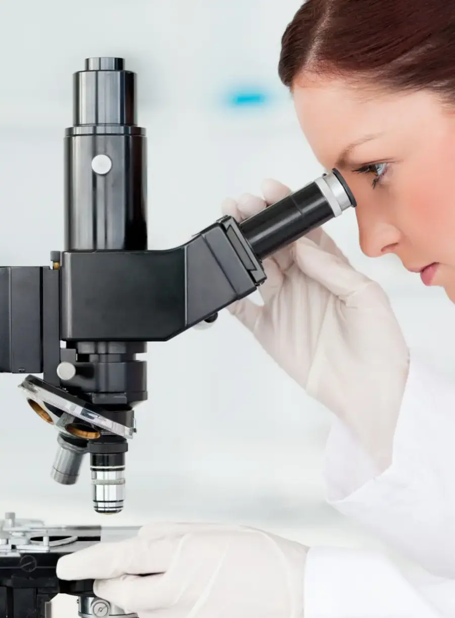 Onderzoeker bekijkt huidstructuren met een microscoop in historische Nora Bode-documentatie